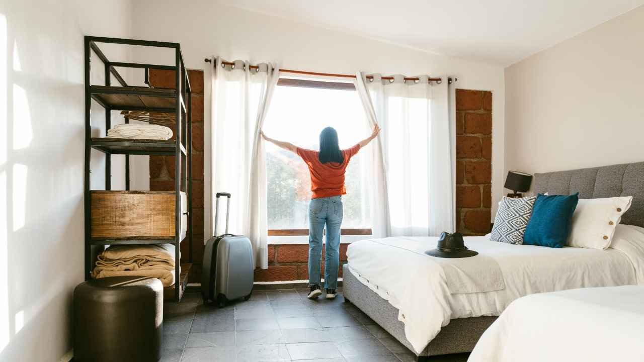 mulher abrindo a bela cortina do quarto